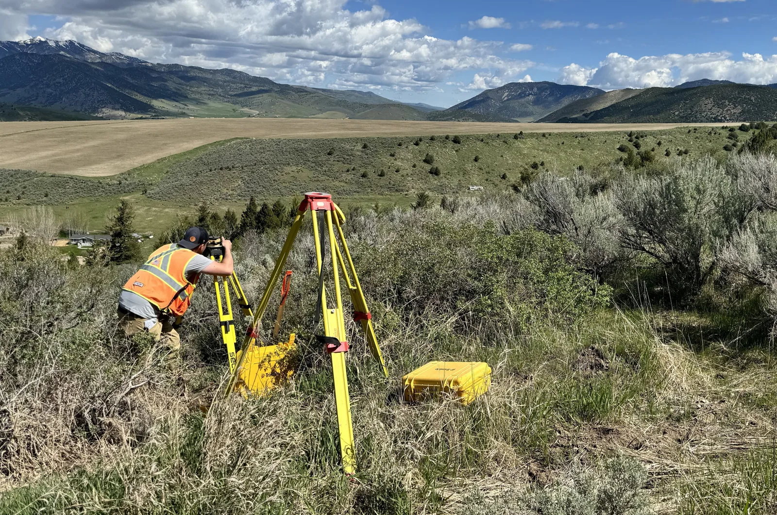 Dioptra surveyor setting up a total station on rangeland above a valley in southeast Idaho